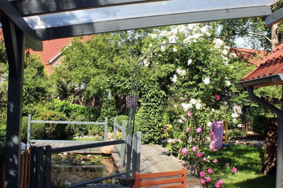 Gartenansicht eines ferienhauses in Greetsiel mit Gartenteich und Strandkorb